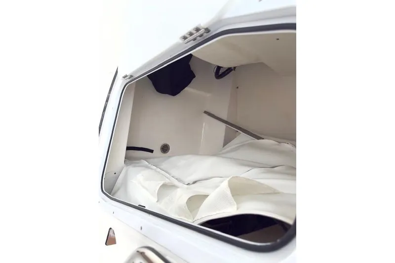 Slide: The Image of 2019 Tidewater 2410 Bay Max boat storage compartment with white interior and gear. - 11
