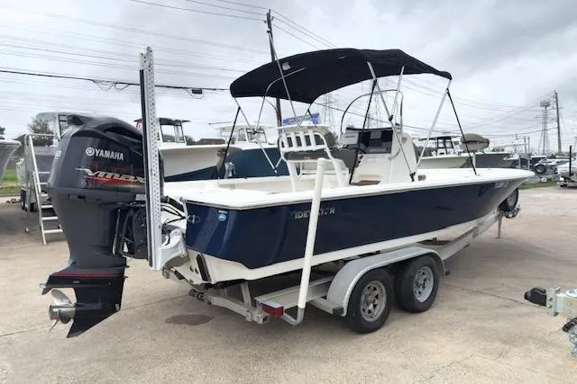 Slide: The Image of 2019 Tidewater 2410 Bay Max boat on trailer with Yamaha engine, parked outdoors. - 2