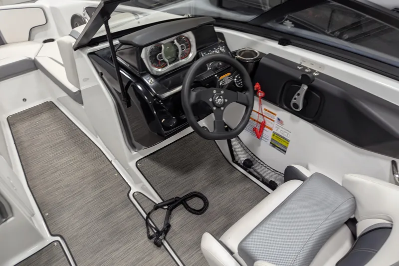 Slide: The Image of Interior of 2023 Scarab 195 ID boat, featuring steering wheel and dashboard controls. - 10