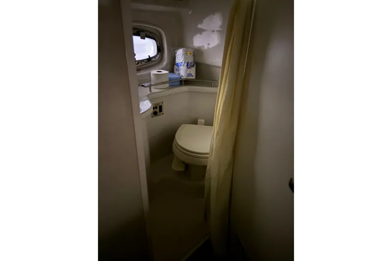 Slide: The Image of 2009 Sea Ray 270 Sundancer bathroom with toilet, window, and toiletries. - 16