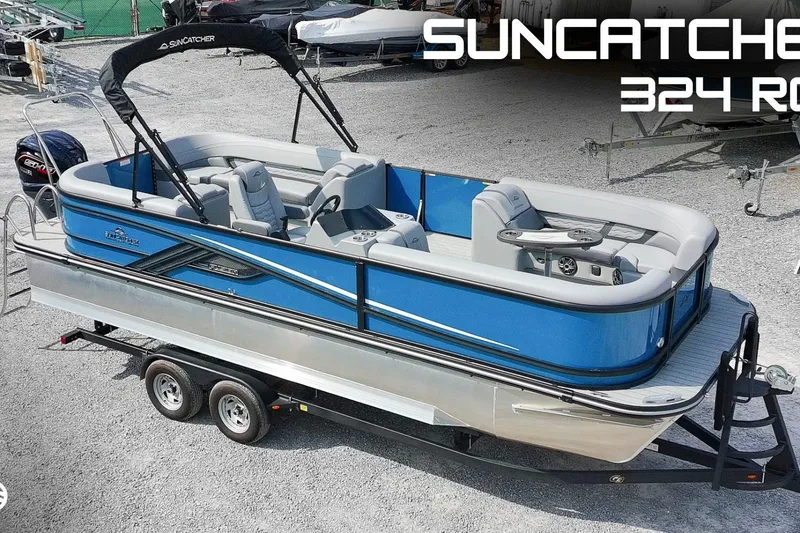 The Image of 2025 SunCatcher Fusion 324RCX pontoon boat on trailer, blue and silver design. - 1