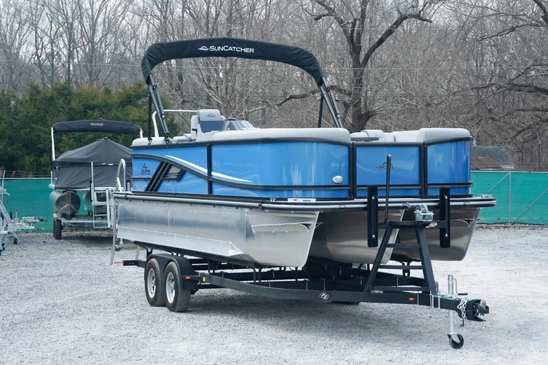 Slide: The Image of 2025 SunCatcher Fusion 324RCX pontoon boat on trailer, parked outdoors. - 3