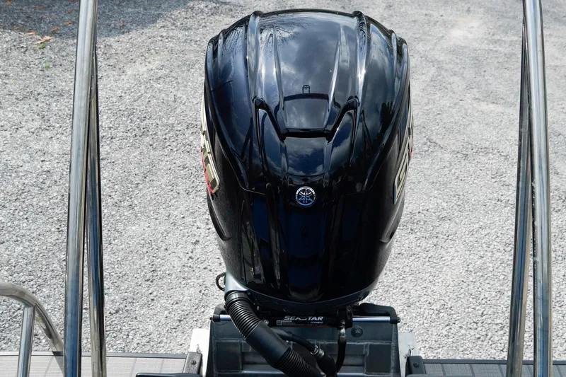 Slide: The Image of 2025 SunCatcher Fusion 324RCX outboard motor, black, on gravel background. - 9
