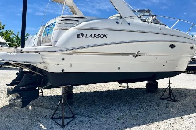 The Image of 2004 Larson 330 boat on stands, white hull, outdoor display. - 0