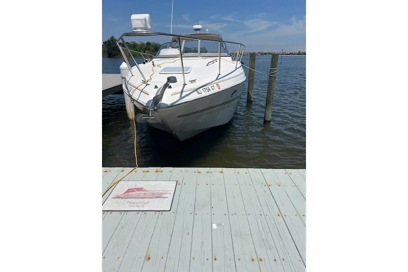 Slide: The Image of 2004 Larson 330 boat docked on a sunny day, with clear blue skies. - 11