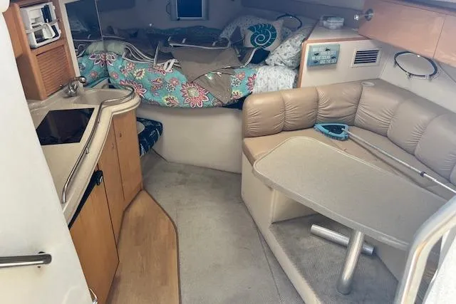 Slide: The Image of Interior of 2004 Larson 330 boat with cozy seating and compact kitchen area. - 7