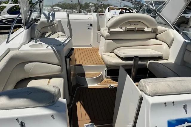Slide: The Image of 2004 Larson 330 boat interior with white seating and wood flooring. - 8