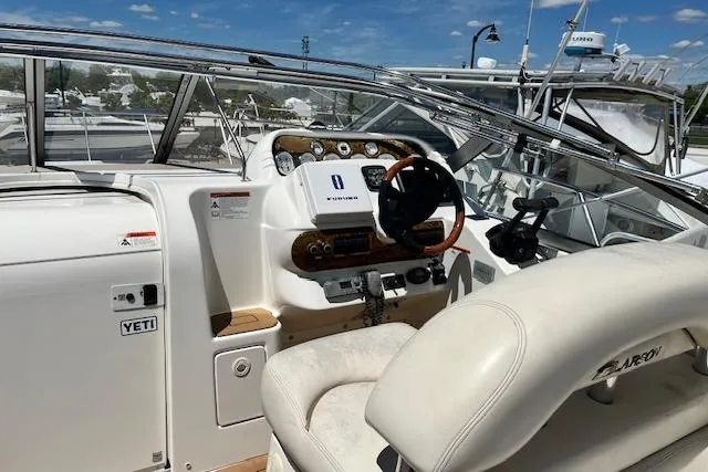 Slide: The Image of 2004 Larson 330 boat cockpit with steering wheel and control panel under clear blue sky. - 9