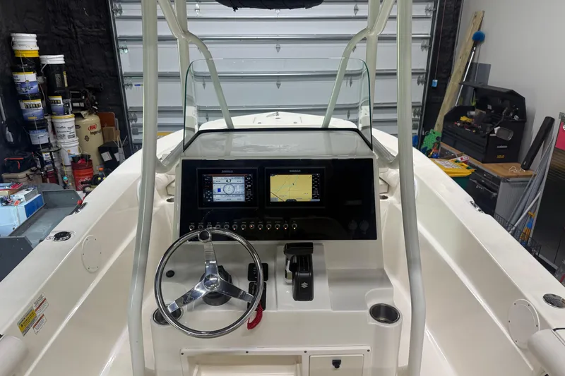 Slide: The Image of 2021 Seaborn LX22 boat dashboard with dual displays and steering wheel in a garage setting. - 11