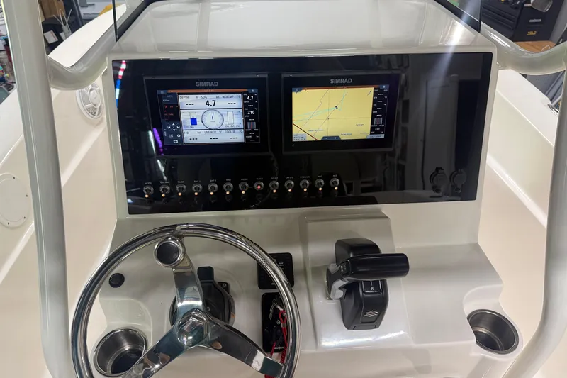 Slide: The Image of Steering console of 2021 Seaborn LX22 boat with dual Simrad displays and controls. - 12