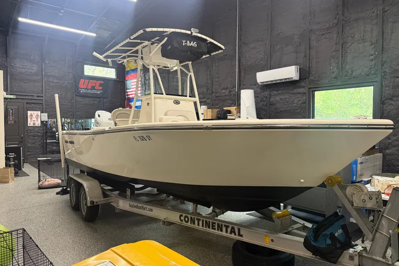 Slide: The Image of 2021 Seaborn LX22 boat on trailer in garage with UFC banner. - 16