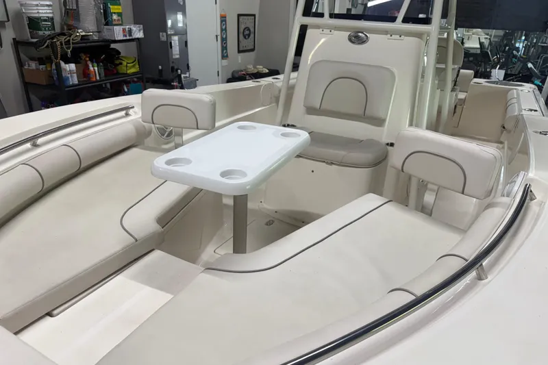 Slide: The Image of 2021 Seaborn LX22 boat interior with white seating and table in a showroom. - 5
