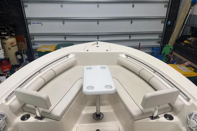 Slide: The Image of 2021 Seaborn LX22 boat interior with white seating and table in a garage. - 6