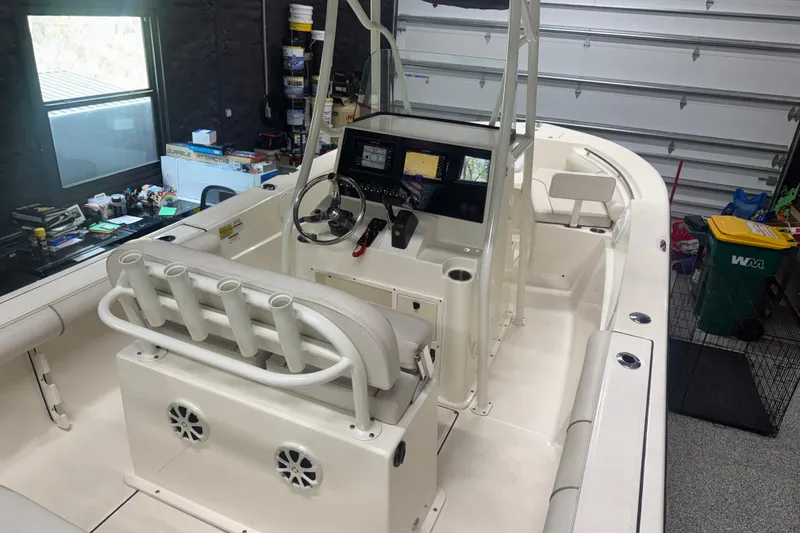 Slide: The Image of 2021 Seaborn LX22 boat interior with steering console and rod holders in a garage. - 9