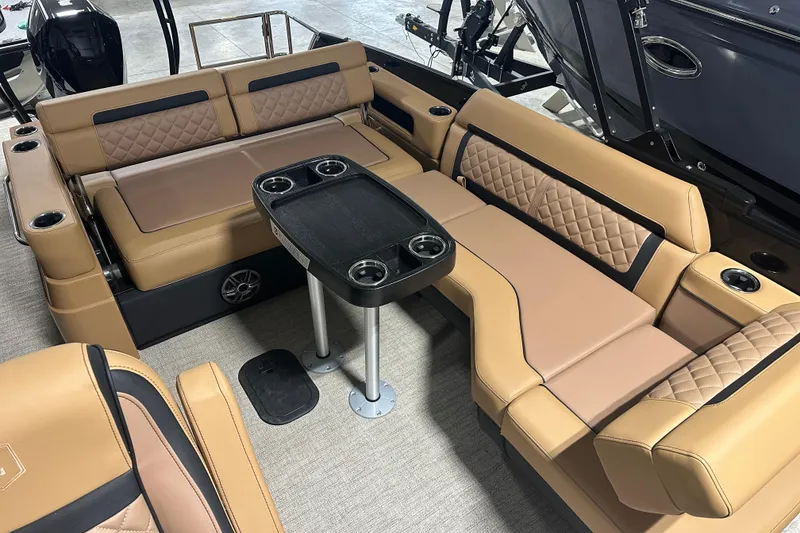 Slide: The Image of Luxurious seating on 2026 Godfrey AquaPatio 255 DFL pontoon boat, featuring tan upholstery and cup holders. - 18