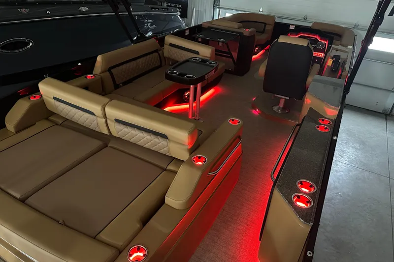 Slide: The Image of Luxurious 2026 Godfrey AquaPatio 255 DFL pontoon boat interior with ambient red lighting. - 2