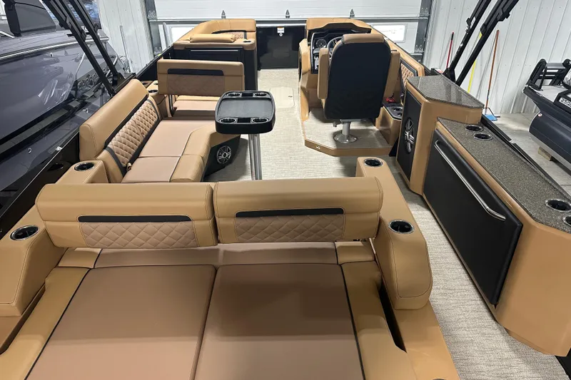 Slide: The Image of Luxurious seating on 2026 Godfrey AquaPatio 255 DFL boat, featuring tan upholstery and cup holders. - 25