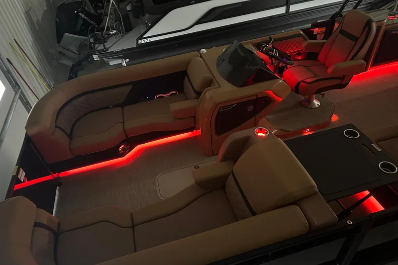 Slide: The Image of Luxurious 2026 Godfrey AquaPatio 255 DFL boat interior with ambient red lighting and plush seating. - 6