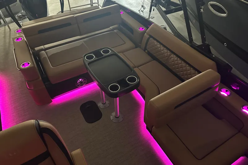 Slide: The Image of Luxurious 2026 Godfrey AquaPatio 255 DFL boat interior with ambient red lighting and plush seating. - 7