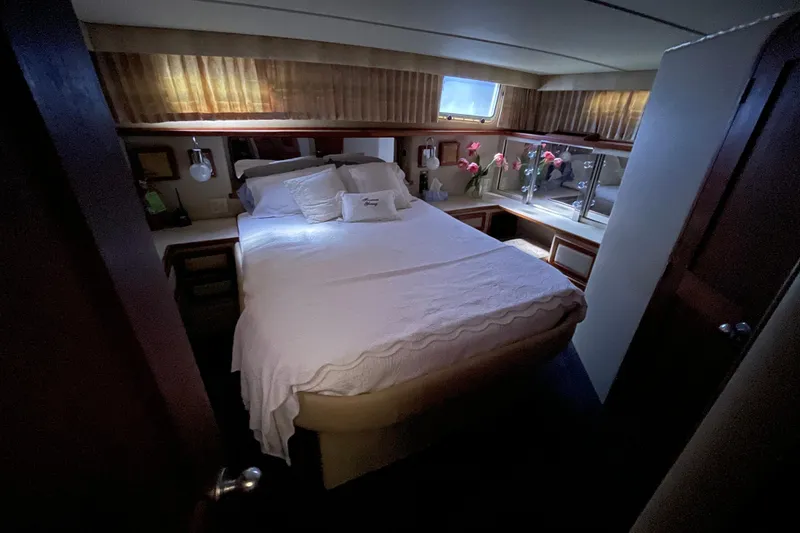 Slide: The Image of 1985 Chris-Craft 426 Catalina cabin interior with bed, flowers, and window. - 25