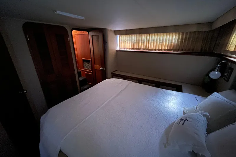 Slide: The Image of Cozy bedroom interior of 1985 Chris-Craft 426 Catalina yacht with bed and wooden accents. - 27