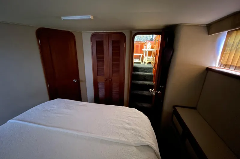 Slide: The Image of 1985 Chris-Craft 426 Catalina cabin interior with bed, doors, and stairs leading outside. - 28