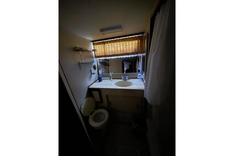 Slide: The Image of 1985 Chris-Craft 426 Catalina bathroom with sink, mirror, and toilet. - 32