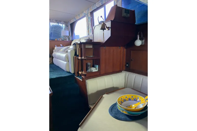 Slide: The Image of 1985 Chris-Craft 426 Catalina interior with cozy seating and elegant wooden cabinetry. - 38