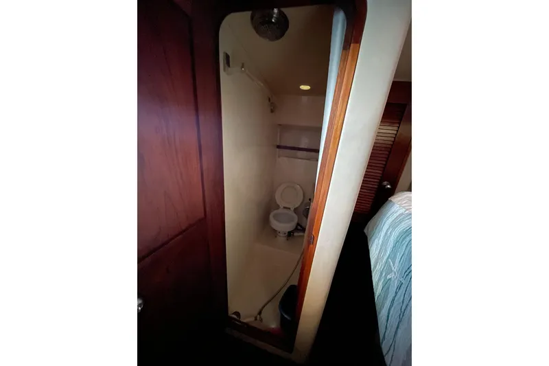 Slide: The Image of 1985 Chris-Craft 426 Catalina bathroom interior with wooden door and compact toilet. - 41