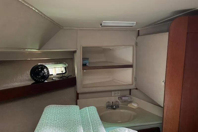 Slide: The Image of 1985 Chris-Craft 426 Catalina cabin interior with sink, shelves, and fan. - 42