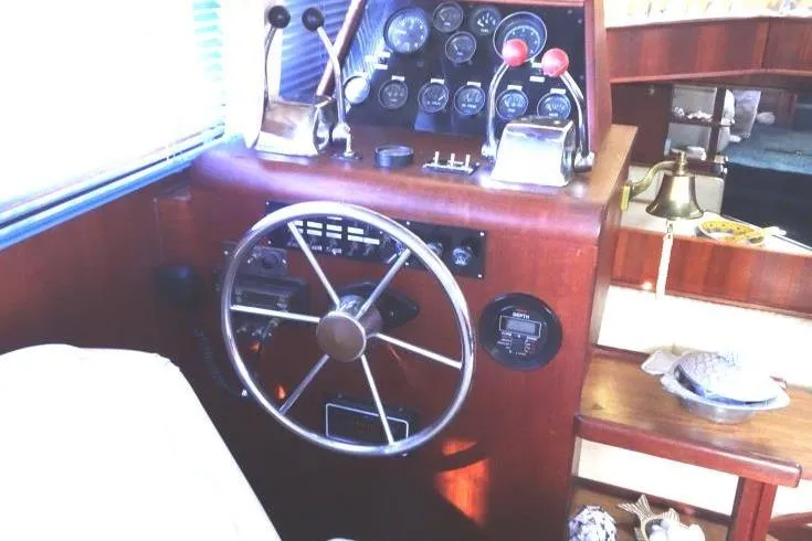 Slide: The Image of 1985 Chris-Craft 426 Catalina yacht docked at a marina, featuring blue and white design. - 5