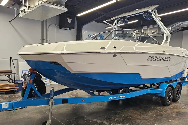 Slide: The Image of 2026 Moomba Max boat on trailer in indoor showroom setting. - 2