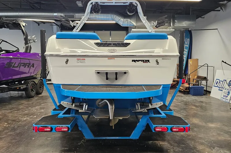 Slide: The Image of 2026 Moomba Max boat in showroom, featuring Raptor engine and vibrant blue accents. - 6