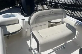Slide: The Image of 2023 Sailfish 220 CC boat interior with cushioned seating and storage compartments. - 11