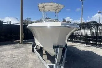 Slide: The Image of 2023 Sailfish 220 CC boat on trailer, parked outdoors under clear blue sky. - 3