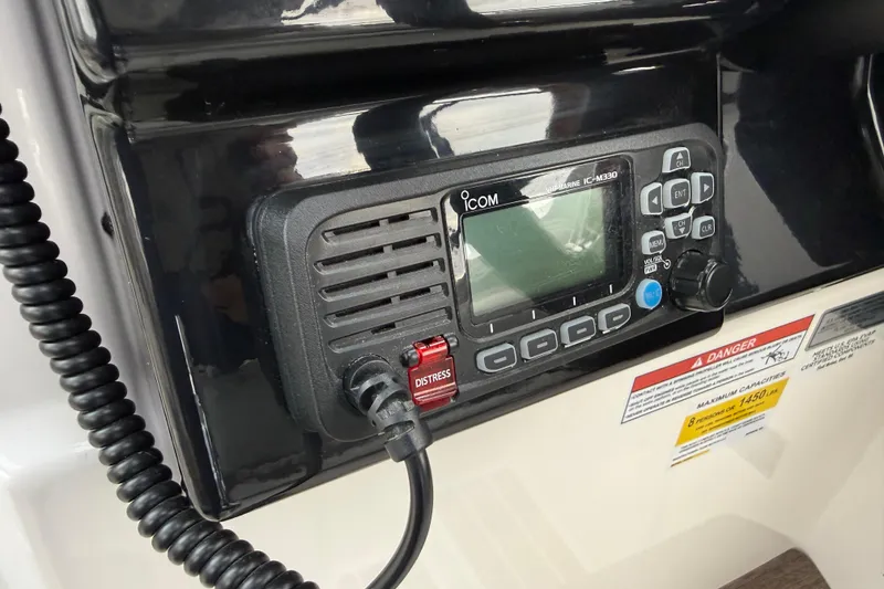 Slide: The Image of 2024 Solara S-250 Coupe marine radio with distress button and warning labels. - 22