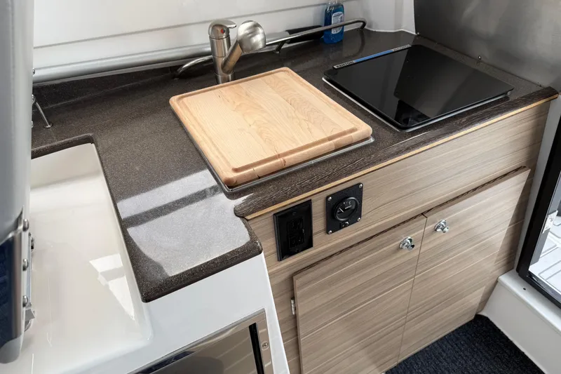 Slide: The Image of Compact kitchen area in 2024 Solara S-250 Coupe with sink, cutting board, and stove. - 25