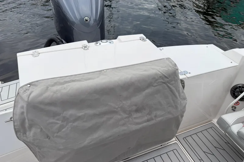 Slide: The Image of 2024 Solara S-250 Coupe boat stern with covered engine, docked on calm water. - 42