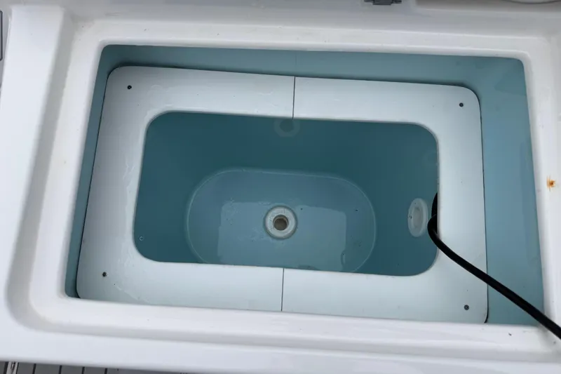 Slide: The Image of Livewell compartment in 2024 Solara S-250 Coupe boat, featuring a clean, white interior. - 46