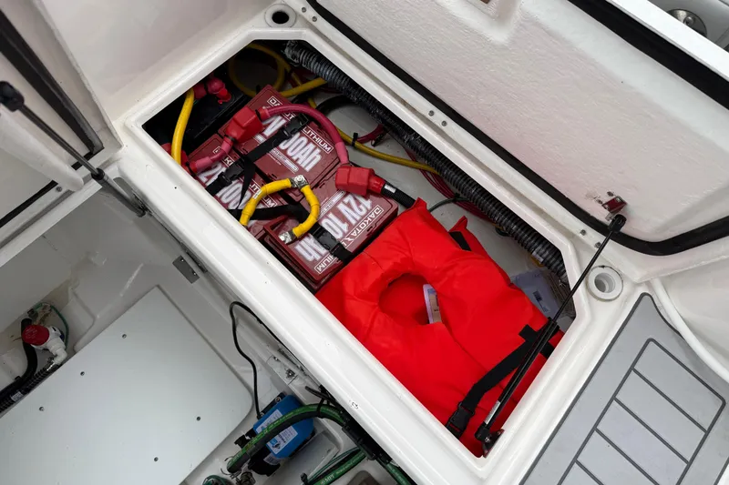 Slide: The Image of 2024 Solara S-250 Coupe storage compartment with batteries and a red life jacket. - 49