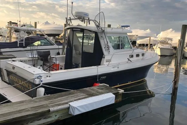 Slide: The Image of 2005 Albin 28 Tournament Express boat docked in a marina, surrounded by other vessels. - 12