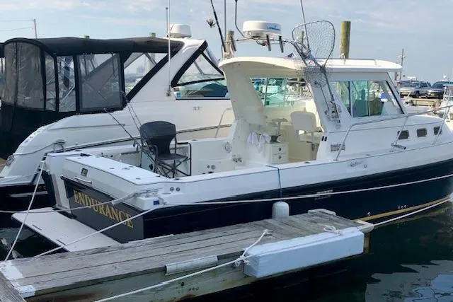 Slide: The Image of 2005 Albin 28 Tournament Express boat docked at marina, featuring spacious deck and cabin. - 3