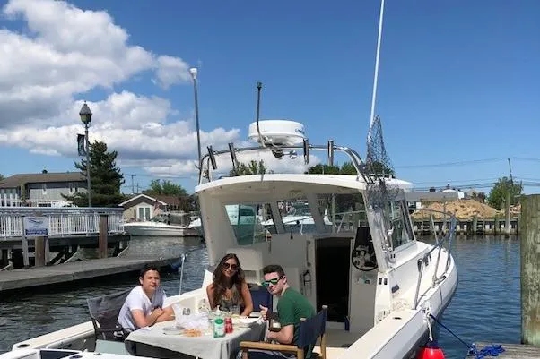 Slide: The Image of 2005 Albin 28 Tournament Express with people dining on deck at a marina. - 8