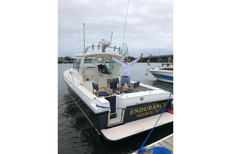 Slide: The Image of 2005 Albin 28 Tournament Express boat docked, person celebrating on deck, "Endurance" labeled. - 9