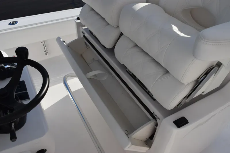 Slide: The Image of 2026 Contender 29 Bay boat interior with white cushioned seating and storage compartment. - 25