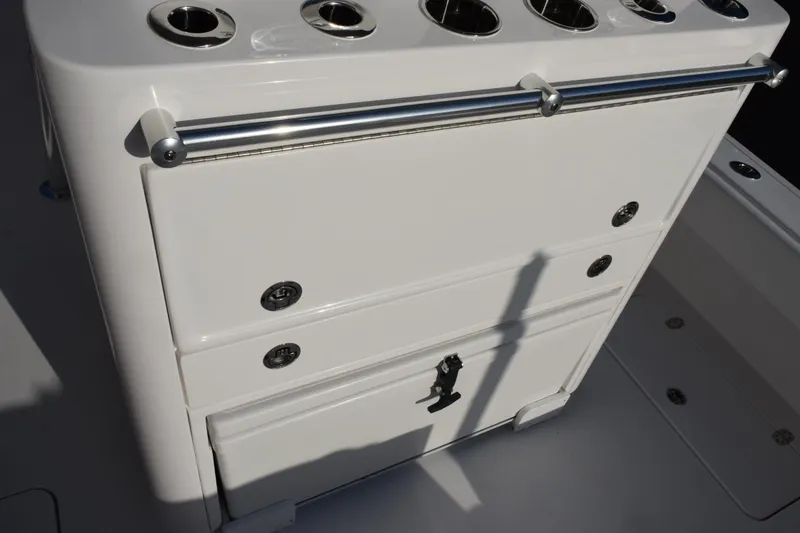 Slide: The Image of 2026 Contender 29 Bay boat storage compartment with rod holders and stainless steel railing. - 9