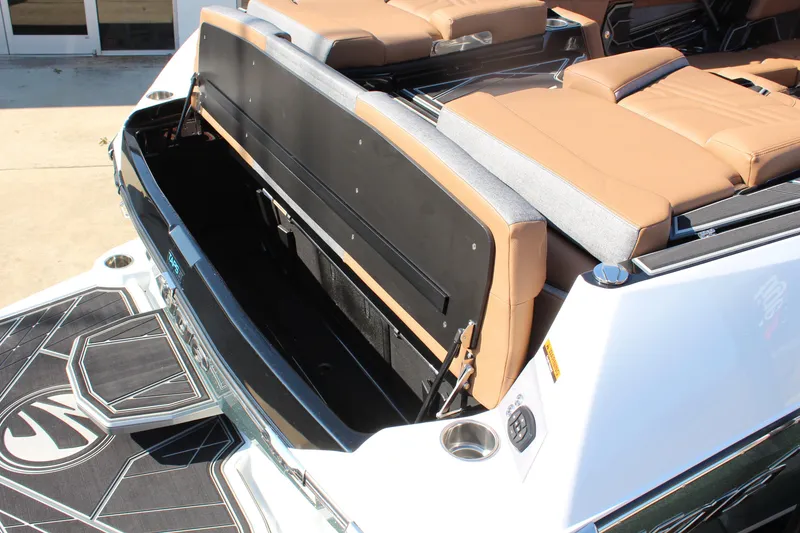 Slide: The Image of 2026 Tigé Ultré 25ZX boat with open storage compartment and tan seating. - 11