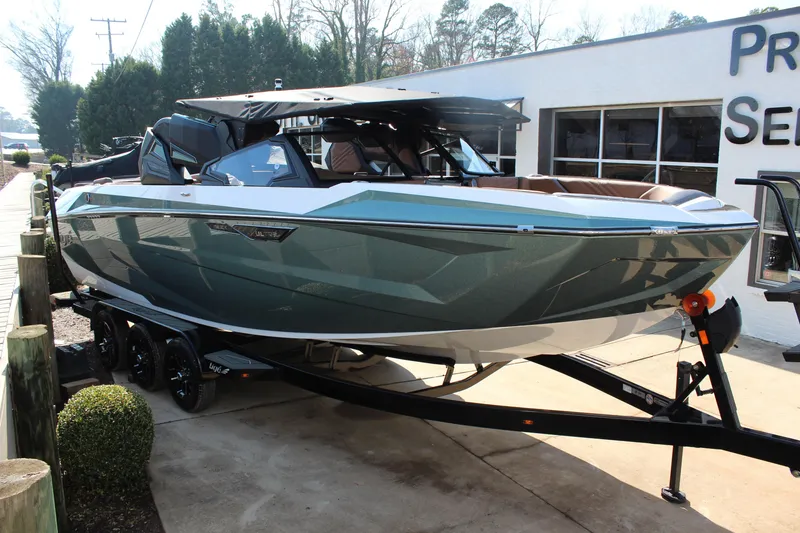 Slide: The Image of 2026 Tigé Ultré 25ZX boat on trailer, sleek design, parked outdoors. - 2
