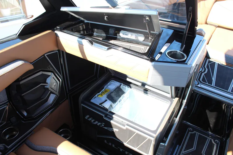 Slide: The Image of 2026 Tigé Ultré 25ZX boat interior with open storage compartments and cup holder. - 23