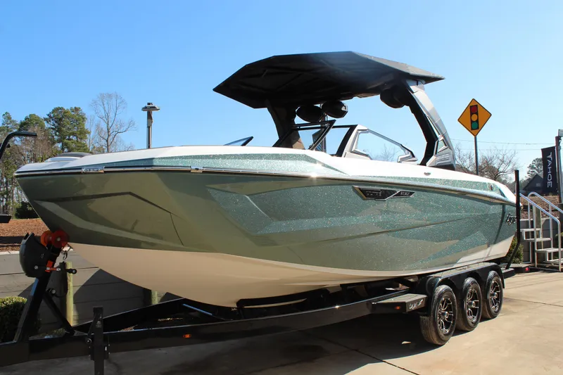 Slide: The Image of 2026 Tigé Ultré 25ZX boat on trailer, sleek design, metallic finish, sunny day. - 3